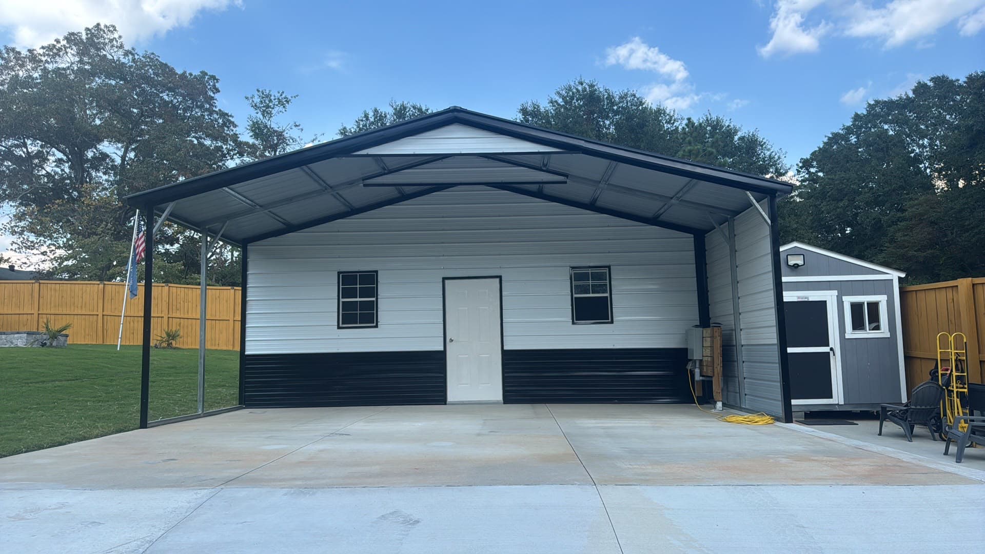 White and black metal garage with an open carport bay